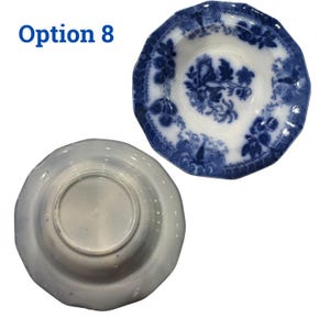 May include: Two antique, white and blue porcelain plates. One plate is face up, displaying a floral design in blue. The other plate is face down, showing the underside. The text "Option 8" is in the upper left corner.