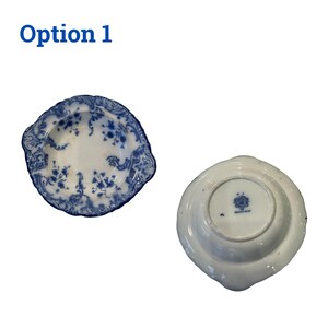 May include: Two antique white and blue porcelain plates. One plate features a floral design and a scalloped edge. The other plate is shown from the underside, with a maker's mark. The text "Option 1" is in the upper left corner.