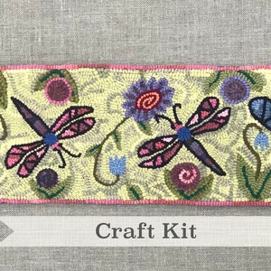 May include: A craft kit featuring a rug hooking pattern with bees, dragonflies, and flowers. The pattern is on a yellow background with green leaves and blue flowers.