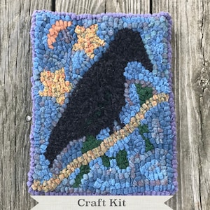 May include: A craft kit featuring a rug hooking pattern of a black crow perched on a branch with yellow and blue flowers. The kit includes all the materials needed to create the rug hooking project.