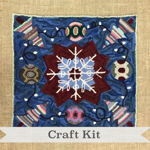 May include: A craft kit featuring a blue and red rug with a snowflake design, surrounded by ornaments and lights. The rug is made of wool and is perfect for a winter-themed craft project. "Craft Kit" is written on a white banner at the bottom of the image.