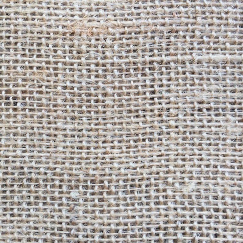 May include: Close-up of a natural brown burlap fabric with a woven texture. The fabric has a rough, coarse feel and is made from natural fibres.
