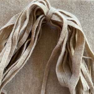 May include: A bundle of beige felt fringe, perfect for adding a touch of texture to your craft projects.