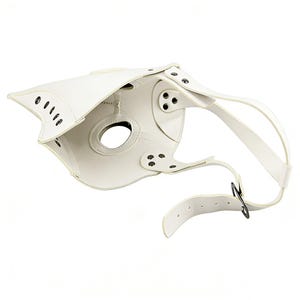 Op de afbeelding: Een witte pestdoktermasker van leerachtig materiaal, met een kenmerkende snavel en oogopeningen. Het heeft riemen en klinknagels voor bevestiging. Het ontwerp is ge&iuml;nspireerd op historische pestdokterkleding.