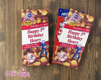 May include: Two red and white cereal boxes with a baseball theme. The boxes have a picture of a baseball player and the text "Prize Inside". The boxes are decorated with a baseball team logo and the text "Happy 5th Birthday Henry".