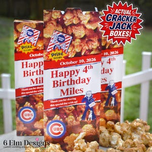 May include: Three custom Cracker Jack boxes with the text "Happy 4th Birthday Miles" and "October 10, 2026". The boxes feature a red and white design with a cartoon sailor and the Cubs logo. Caramel popcorn is in front.