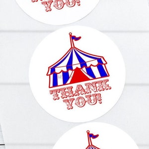 May include: Three white, round stickers with a circus tent design in red, white, and blue. The text "THANK YOU!" is printed in red below the tent. The stickers are on a white background.