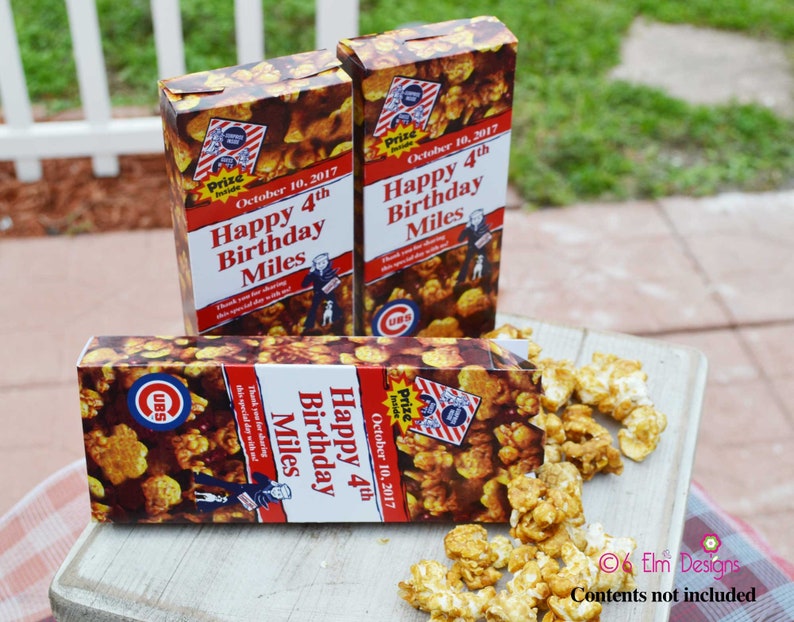 May include: Three popcorn boxes with a caramel corn design. The boxes have the text "Happy 4th Birthday Miles" and "October 10, 2017". The boxes also feature a Cubs logo and a cartoon image of a man with a dog.