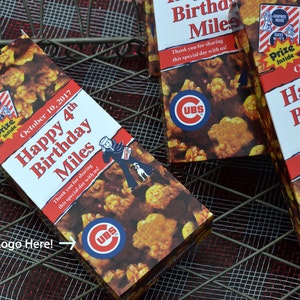 May include: Popcorn boxes with the text "Happy 4th Birthday Miles" and the date "October 10, 2017". The boxes feature a Cubs logo and a cartoon sailor. The popcorn is visible on the boxes.
