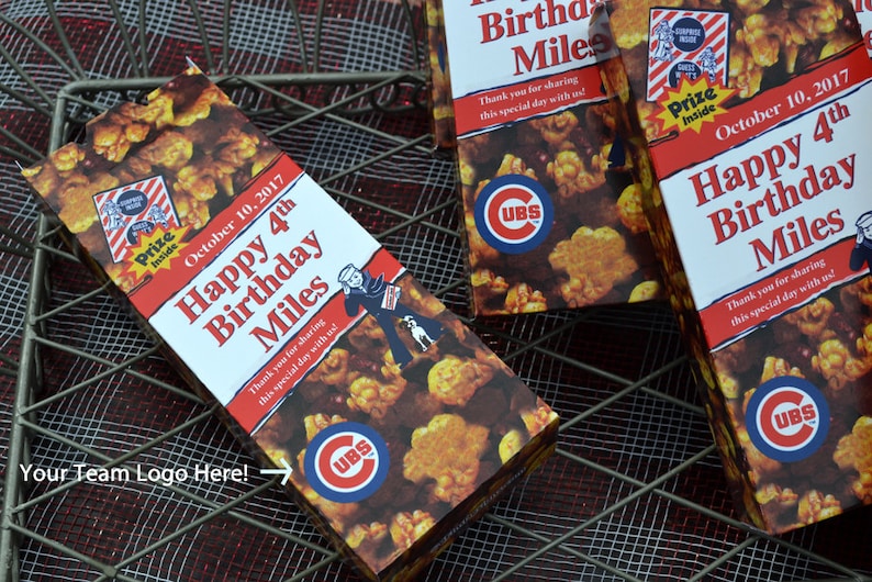 May include: Popcorn boxes with the text "Happy 4th Birthday Miles" and the date "October 10, 2017". The boxes feature a Cubs logo and a cartoon sailor. The popcorn is visible on the boxes.