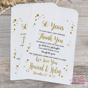 May include: Gold confetti and text on a white paper bag. The text reads "50 Years", "To Our Family and Friends", "Thank You", "For Being a Part of Our Lives", "For All the Love and Laughter", "You Have Given to Us", "Through the Years", "And Those We'll Share for Years to Come!", "We Love You", "Howard & Helen", "November 12, 2022".