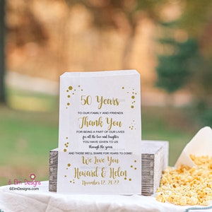 May include: White favor bag with gold text and confetti. The text reads "50 Years", "Thank You", "We Love You", "Howard & Helen", and "November 12, 2022".