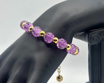 Pulsera artesanal de cuentas de vidrio morado, con separadores chapados en oro de 18k.
