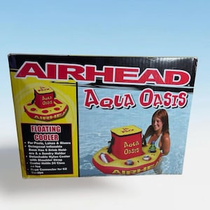 Puede incluir: Una caja para una nevera flotante Airhead Aqua Oasis. La caja presenta una nevera inflable roja y amarilla con portavasos y una nevera desmontable. El texto en la caja dice "Floating Cooler" y "Aqua Oasis".