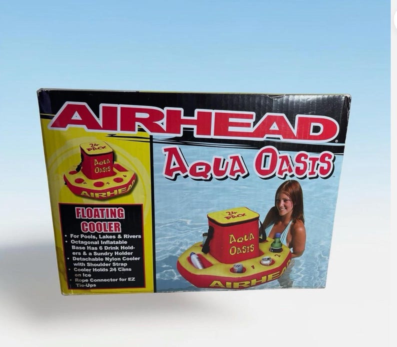 Puede incluir: Una caja para una nevera flotante Airhead Aqua Oasis. La caja presenta una nevera inflable roja y amarilla con portavasos y una nevera desmontable. El texto en la caja dice "Floating Cooler" y "Aqua Oasis".