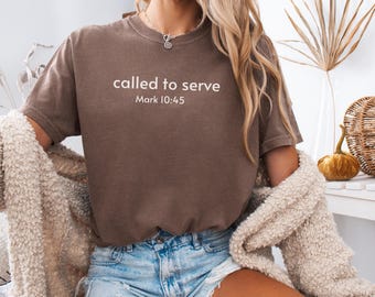 May include: A brown t-shirt with the text "called to serve" and "Mark 10:45" printed in white. The shirt is a short-sleeved crew neck style. The word "Expresso" is printed in the bottom right corner.