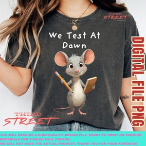 Peut inclure: T-shirt gris foncé avec une souris de dessin animé tenant un crayon et un bloc-notes, avec le texte "We Test At Dawn". Le t-shirt porte également le texte "Third Street" et "Digital File PNG".