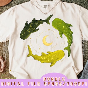 Peut inclure: Un t-shirt à manches courtes couleur crème arborant un motif circulaire de trois requins-baleines dans des tons vert foncé, vert lime et jaune. Chaque requin est orné de lignes de constellations et d'étoiles blanches autour d'un croissant de lune jaune.