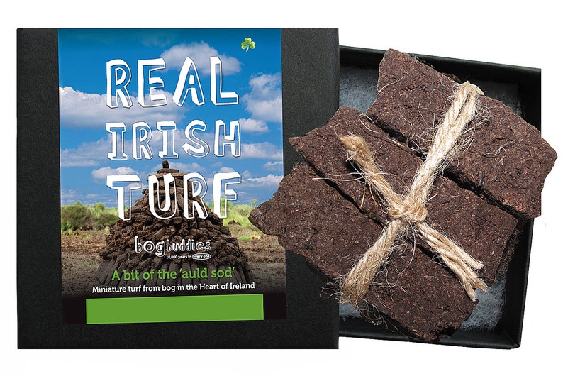 May include: A box of real Irish turf, a small stack of brown peat bricks tied with twine, with a label that reads "Real Irish Turf" and "A bit of the 'auld sod' Miniature turf from bog in the Heart of Ireland."
