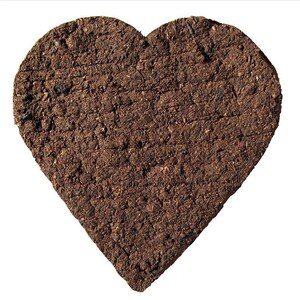 May include: A heart-shaped piece of pressed soil, with a rough, textured surface. The soil is a dark brown color.