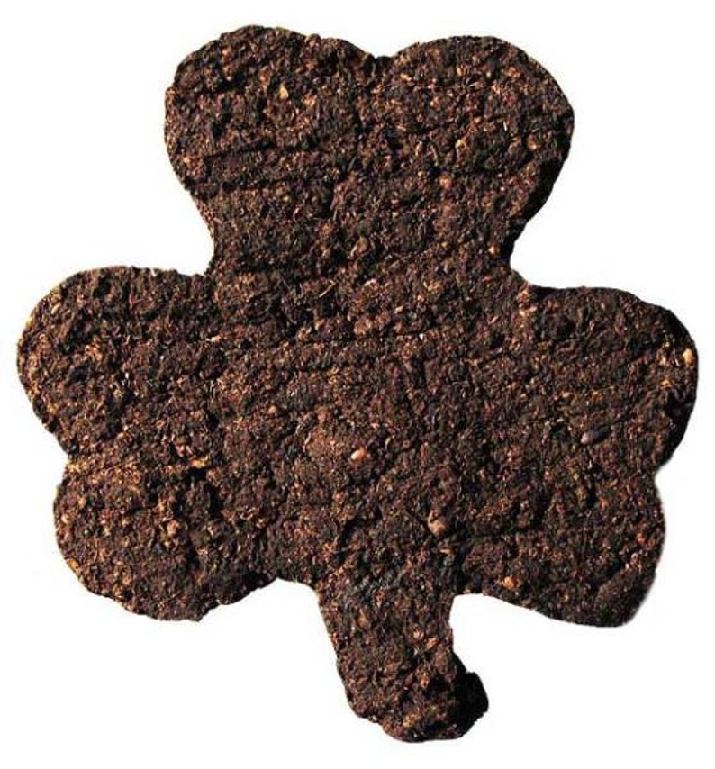 May include: A brown, three-leaf clover-shaped cookie made of soil.
