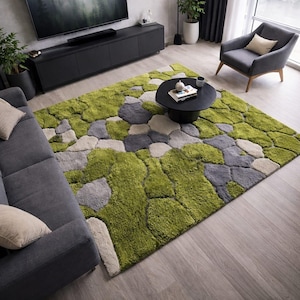 Può includere: Un grande tappeto strutturato con un design unico. Il tappeto presenta un motivo di forme verdi, grigie e beige, che ricordano un paesaggio roccioso o coperto di muschio. Il tappeto è collocato in un soggiorno.