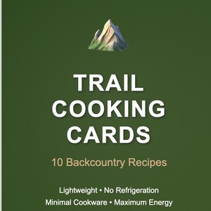 Puede incluir: Una tarjeta verde con las palabras "TRAIL COOKING CARDS" en blanco. La tarjeta también dice "10 Backcountry Recipes" y enumera características como "Ligero" y "Sin refrigeración". Una ilustración de montaña está en la parte superior.