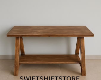 Puede incluir: Mesa de centro rectangular de madera con una balda inferior. La mesa es de madera de tono medio y tiene un diseño sencillo y moderno. El texto "SWIFTSHIFTSTORE" está impreso en la parte inferior.