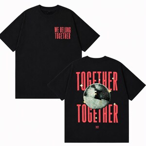 May include: Black t-shirt with the text "WE BELONG TOGETHER" in red on the front. The back of the shirt features the words "TOGETHER" above and below a disco ball graphic, with the year "2023" at the bottom.