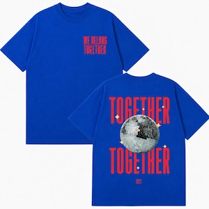 May include: Royal blue t-shirts with red text. One shirt has "WE BELONG TOGETHER" on the front. The other shirt has "TOGETHER" above and below a disco ball graphic, with "2023" at the bottom.