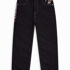 May include: Dark wash denim jeans with decorative floral embroidery on the front pocket and side seam. The jeans have a straight leg cut and classic five-pocket styling. The embroidery features pink and white flowers and a crane.