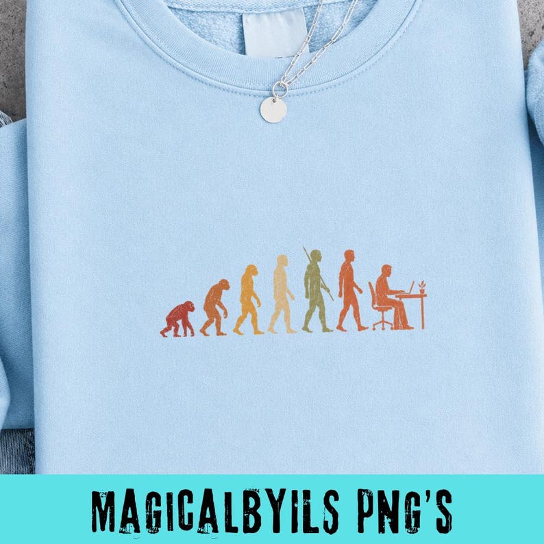 May include: A light blue crewneck sweatshirt featuring an embroidered graphic of human evolution, progressing from a primate to a person sitting at a desk with a laptop. A silver chain necklace with a small circular pendant rests at the neckline.