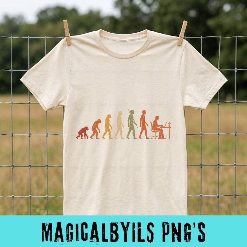 May include: A cream-colored short-sleeve t-shirt featuring a graphic print of human evolution. The design shows a progression from a primate to a human sitting at a desk with a computer, rendered in shades of orange, brown, and green.