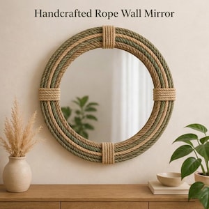 Puede incluir: Espejo de pared de cuerda hecho a mano. Un espejo redondo con un marco de cuerda tejida en tonos verdes y beige. El espejo está asegurado con secciones de cuerda enrollada. El texto "Handcrafted Rope Wall Mirror" está en la parte superior.