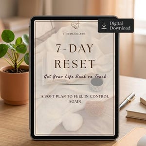 May include: A digital tablet displays a self-help guide titled "7-DAY RESET." The cover features text, a cup, and a book on a soft, neutral-toned background. A "Digital Download" button is in the upper right corner. The tablet rests on a wooden desk.