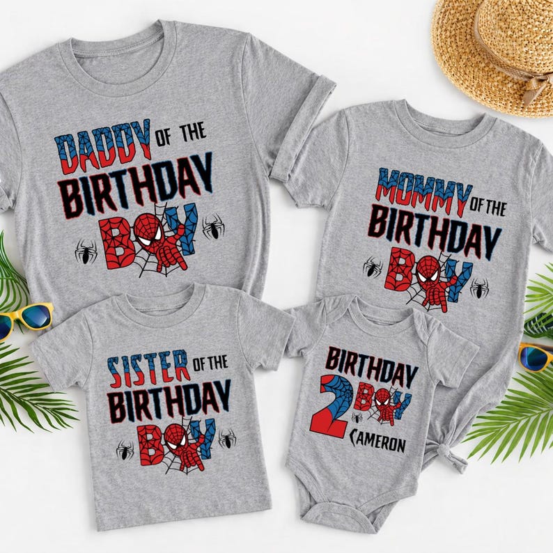 May include: Gray t-shirts and a onesie with a Spider-Man theme. The shirts read "Daddy of the Birthday Boy," "Mommy of the Birthday Boy," and "Sister of the Birthday Boy." The onesie says "Birthday Boy" and has the name "Cameron."