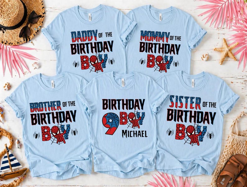 May include: Light blue t-shirts with various text designs for a birthday celebration. The shirts read "Daddy of the Birthday Boy," "Mommy of the Birthday Boy," "Brother of the Birthday Boy," "Birthday Boy 9 Michael," and "Sister of the Birthday Boy."
