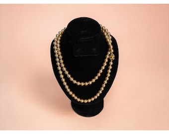 Collana Nolan Miller da 36 pollici con perle finte, chiusura color oro con cristallo blu, lunghezza opera.