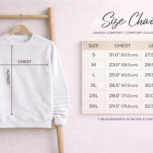 May include: A white crewneck sweatshirt hanging on a wooden hanger, accompanied by a size chart titled Size Chart Unisex Comfort Comfort Colors 17175. The chart lists chest and length measurements in inches from sizes S to 3XL for this garment.