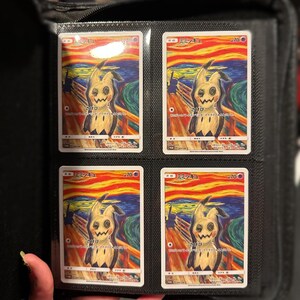 May include: Four trading cards featuring a Mimikyu character in a parody of Edvard Munch's "The Scream" painting. The cards are in a black binder, each card displaying the character against a swirling orange, yellow, and blue background. Japanese text is visible on the cards.