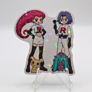 May include: A holographic sticker featuring two cartoon characters with the letter "R" on their shirts, and two cartoon creatures. The characters are in white outfits with black accents. The sticker has a sparkly background.