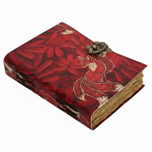 Könnte beinhalten: Rotes Lederjournal mit Fuchsmotiv. Der Einband zeigt ein sich wiederholendes Blättermuster und eine Fuchsgrafik. Das Journal hat einen Metallverschluss und gealterte Papierseiten.