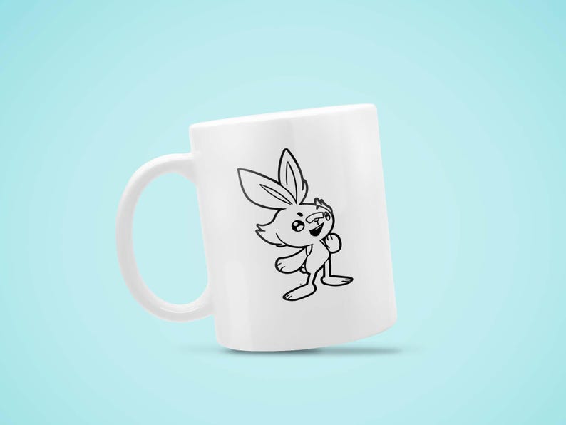 May include: White ceramic mug featuring a black and white cartoon rabbit illustration. The rabbit has large ears and is smiling. The mug has a curved handle and is set against a light blue background.