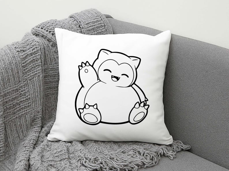 May include: White square pillow featuring a black and white cartoon illustration of a Snorlax character. The Snorlax is waving with a happy expression. The pillow is on a gray couch with a gray knitted throw blanket.