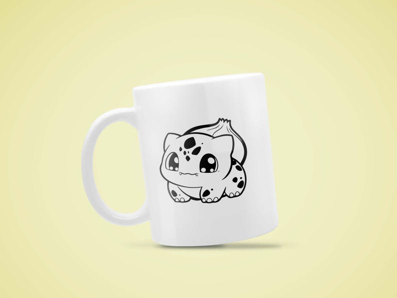 May include: White ceramic mug featuring a black and white cartoon illustration of a Bulbasaur. The Bulbasaur design includes large eyes and black spots. The mug has a curved handle and is set against a yellow background.