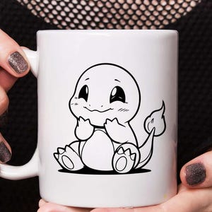 May include: White ceramic mug featuring a black and white illustration of a cartoon character. The character has a round head, large eyes, and a smiling expression. The mug is held by a person.