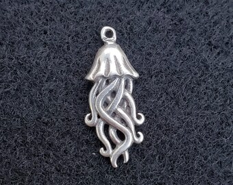 May include: Silver charm in the shape of a jellyfish with a detailed design. The charm has a domed top and intricate tentacles.