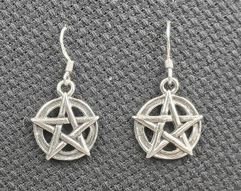 May include: A pair of silver earrings with a pentagram design. The earrings are made of metal and have a simple, elegant design.