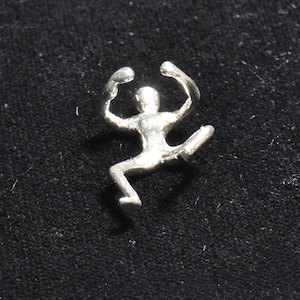 May include: A silver figurine of a person in a jumping pose with arms raised above their head.