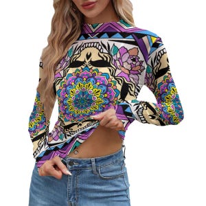 Pode incluir: Uma camisa de manga comprida com gola alta. A camisa apresenta um padrão vibrante e colorido com desenhos florais e geométricos em tons de roxo, azul, amarelo e preto. A camisa é feita de um material macio e confortável.